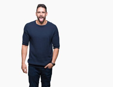 Yakışıklı delikanlı dilini izole arka plan üzerinde kazak giyen out komik ifade ile mutlu. Duygu kavramı.