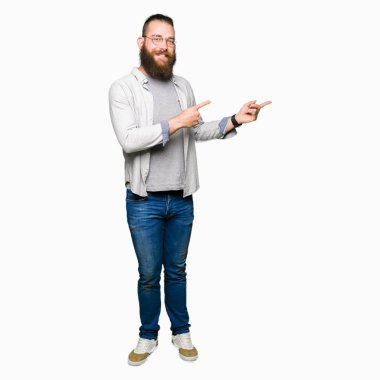 Genç sarışın adam gözlüklü ve kamera iki el ve parmak tarafına işaret görünümlü gözlük giyiyor.