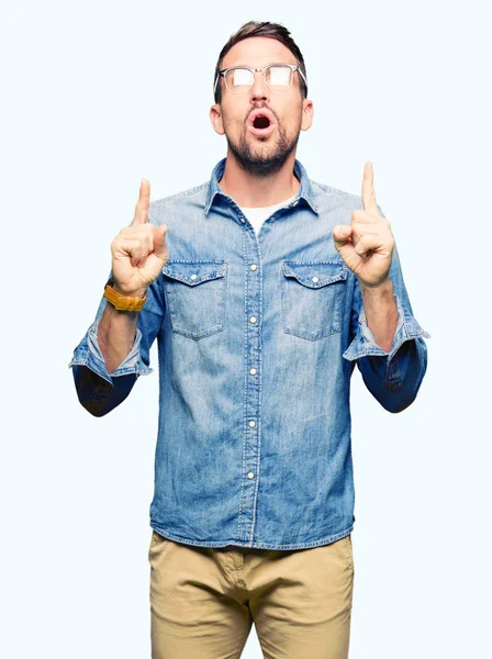 Hombre Guapo Con Gafas Asombrado Sorprendido Mirando Hacia Arriba Señalando — Foto de Stock