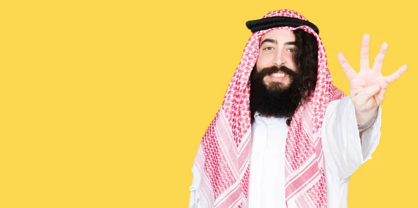 阿拉伯商人长头发戴着传统的Keffiyeh围巾显示和指着手指四 同时微笑自信和快乐 — 图库照片
