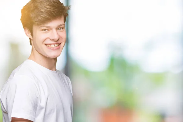 年轻英俊的男人穿着休闲白色 T恤在孤立的背景与一个快乐和冷静的笑容在脸上 幸运的人 — 图库照片