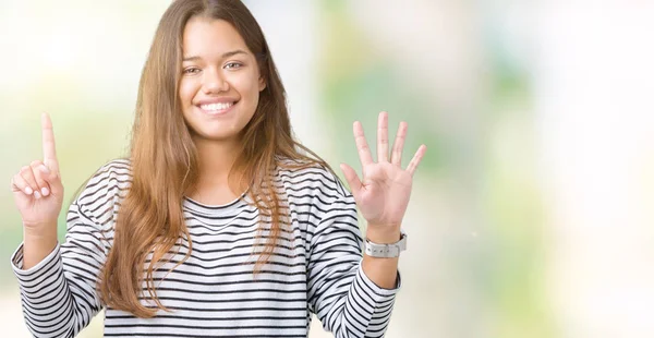 分離背景表示と指で上向きに若い美しいブルネットの女性着用のストライプ セーター ナンバー 自信を持って 幸せな笑みを浮かべて — ストック写真