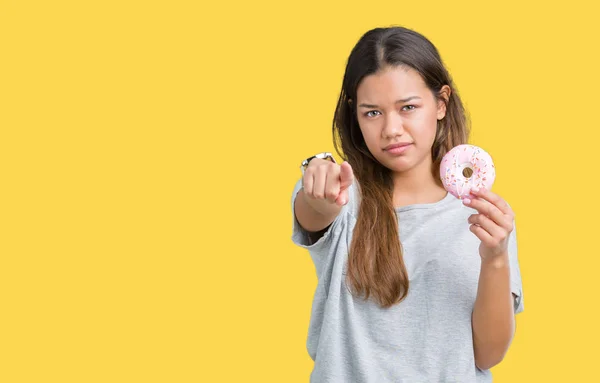 Jovem Mulher Bonita Comendo Donut Rosa Sobre Fundo Isolado Apontando — Fotografia de Stock