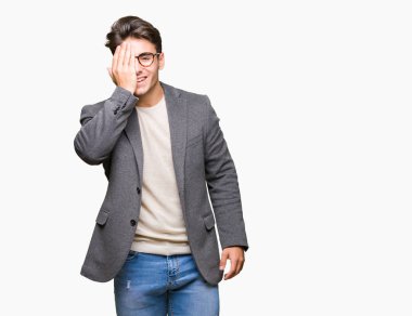 El yüz ve sürpriz duygu kendinden emin gülümseme ile tek gözüyle kapsayan izole arka plan üzerinde gözlük takan genç iş adamı.