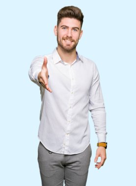 Tebrik ve konuksever dost sunan karşılıklı gülümseyen genç yakışıklı iş adamı. Başarılı iş.