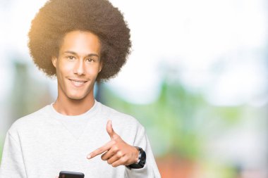 Genç African Amerikan adam ile afro saç kullanarak bir smartphone çok mutlu işaret ile el ve parmak