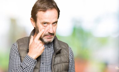 Orta Çağ yakışıklı adam Kışlık yelek giyiyor göz Işaret sizi jest izlerken, şüpheli ifade