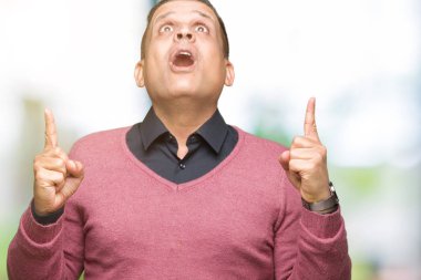 Orta yaş Arap adam izole arka plan üzerinden hayran ve yukarıya bakıp parmakları ile işaret şaşırttı ve silah kaldırdı.