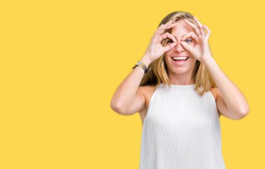 Güzel genç zarif kadın dilini, parmaklarının arasından baktığını yapışmasını dürbün gibi ok jest yapıyor izole arka plan yüzünden. Deli ifade.