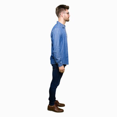 Genç yakışıklı zarif adam giyen denim ceket tarafına, seyir dinlenmek doğal yüz emin gülümseme ile pozuyla profil.