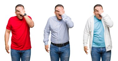 Mahcup ifadeyle parmaklarımın arasından bakan Arap orta yaş adam yüz ve gözler el ile kapsayan şok bakmak izole arka plan üzerinde bileşimi.