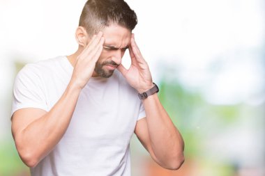 Genç adam giyiyor rahat beyaz t-shirt baş baş ağrısı için el ile izole arka plan üzerinde çünkü stres. Migren muzdarip.