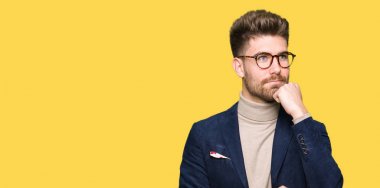 Gözlüklü el ile çene düşünme hakkında soru, dalgın ifade üzerine genç yakışıklı iş adamı. Düşünceli yüzüyle gülümsüyor. Şüphe kavramı.