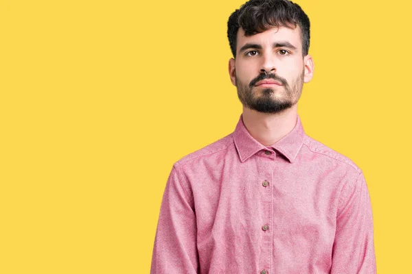 若いハンサムな男の顔に真剣な表情で孤立した背景リラックスにピンクのシャツを着てします シンプルで自然なカメラを見てください — ストック写真