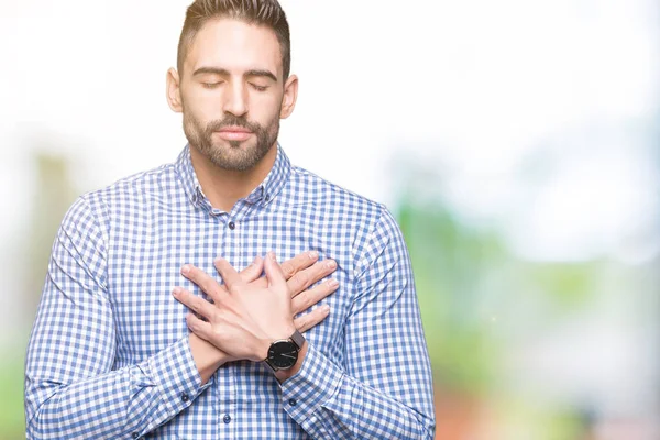 Yakışıklı delikanlı ile gülümseyen izole arka plan üzerinde kapalı gözler ve yüzünde minnettar jest ile göğüs üzerinde eller. Sağlık kavramı.