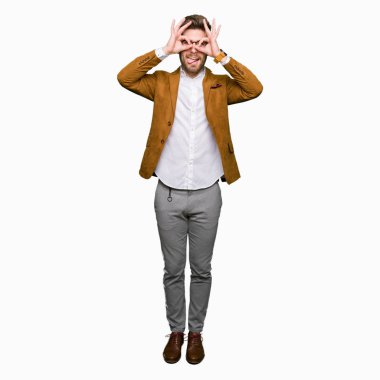 Dilini, parmaklarının arasından baktığını yapışmasını dürbün gibi ok jest yapıyor gözlüklü genç yakışıklı iş adamı. Deli ifade.