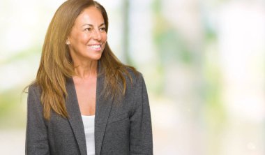 Üzerinde büyük boy erkek ceket giyen orta yaş yetişkin kadın arka plan uzak tarafına gülümseme ile yüzünde, doğal ifade arıyorum izole. Kendine güvenen gülüyor.