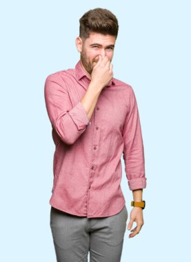 Genç yakışıklı iş rahat adam kokmuş ve mide bulandırıcı, dayanılmaz koku, burun parmaklarıyla nefes tutan bir şey kokusu. Kötü koku kavramı.