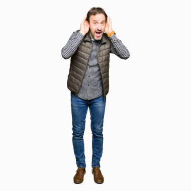 Orta Çağ yakışıklı adam kış yeleği giyiyor iki elini de kulak jestinde duymaya çalışıyorum, dedikoduyu merak ediyor. İşitme sorunu, sağır