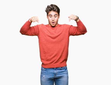 İzole genç yakışıklı adam arka plan işaretleme aşağı reklam, sürpriz yüz ve açık ağız gösterilen parmakları ile