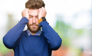 Genç yakışıklı bussines adam çünkü umutsuz ve stresli baş ağrısı acı acı ve migren. Ellerini kafasına.