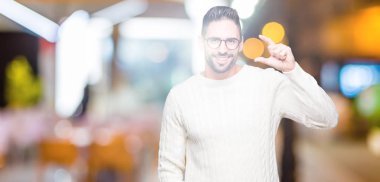 İzole arka plan gülümseyen ve süre seyir ve kamera boyutu işaret parmaklarıyla yapıyor el ile kendinden emin eller üzerinde gözlük takan yakışıklı delikanlı. Ölçü kavramı.