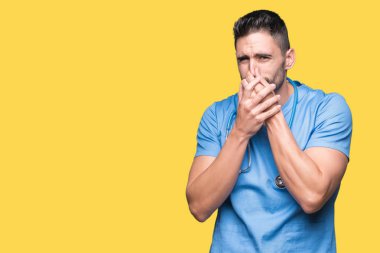 Yakışıklı genç doktor cerrah adam bir şey pis ve iğrenç kokulu izole arka plan, dayanılmaz koku, holding nefes burun parmaklar ile. Kötü kokuyor kavramı.