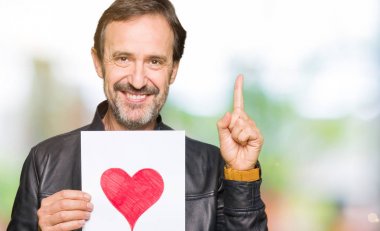 Bir fikir ya da soru işaret parmağı ile gülen yüz, bir numara kırmızı kalp ile kağıt tutan yakışıklı orta yaş adam şaşırttı