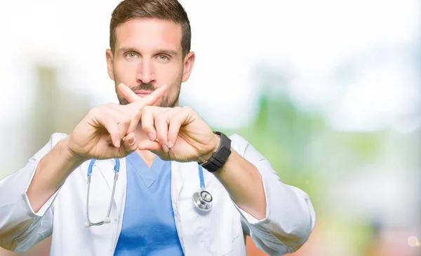 英俊的医生人穿医疗制服在孤立的背景拒绝表达交叉手指做消极的标志 — 图库照片