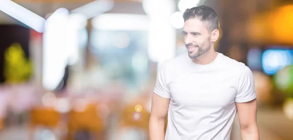 Jovem Vestindo Camiseta Branca Casual Sobre Fundo Isolado Olhando Para — Fotografia de Stock