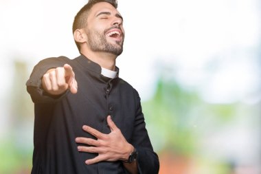 Genç Hıristiyan rahip izole üzerinde arka plan sizin parmak el kamerasıyla göğüs üzerinde utanç ifadesi işaret eden gülme