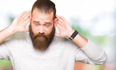 Kulak jest, dedikodu için meraklı her iki ellerde dinliyoruz rahat kazak giyen genç sarışın adam. İşitme sorunu, sağır