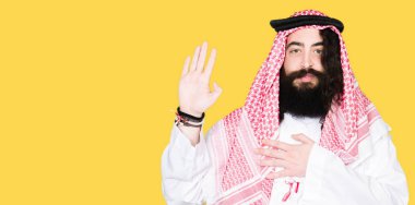 Arap iş adamı geleneksel keffiyeh giymiş uzun saçlı eşarp Swearing göğüs ve avuç el ile bir sadakat sözü yemin yapımı