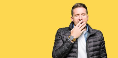 Yakışıklı adam kış palto giyiyor el ağzıyla kapsayan yorgun esneme sıkılmış. Restless ve uyku hali.