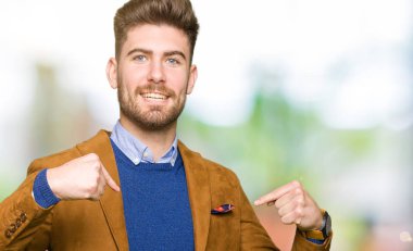 Yüzünde gülümseme ile kendinden emin görünüyorsun, kendini gururlu ve mutlu parmakları ile işaret genç yakışıklı iş adamı.