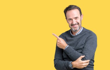 Yakışıklı orta yaş komuta sizde bir kazak izole üzerinde giyen reklam, ciddi ve sakin yüz gösterilen yan el parmak ile işaret arka plan