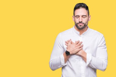 İzole arka plan üzerinde genç iş adamı gözleri kapalı gözler ve yüz minnettar jest ile göğsüne el ile gülümsüyor. Sağlık konsepti.