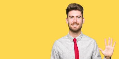 Gösterilen ve parmakları ile işaret genç yakışıklı iş adamı kendinden emin ve mutlu gülümseyerek süre beş numara.