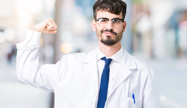 年轻的专业科学家男子穿着白色外套在孤立的背景坚强的人显示手臂肌肉 自信和自豪的权力 — 图库照片