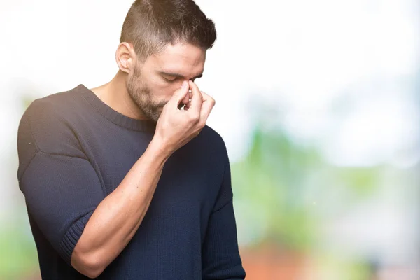 Young handsome man wearing sweater over isolated background tired rubbing nose and eyes feeling fatigue and headache. Stress and frustration concept.