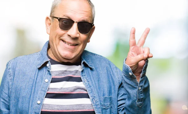 Przystojny Mężczyzna Senior Noszenia Kurtka Dżinsowa Okulary Przeciwsłoneczne Uśmiechając Się — Zdjęcie stockowe