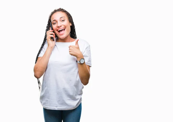 年轻的辫子头发非洲裔美国女孩通过智能手机在孤独的背景下打电话来 高兴地看到大大的笑容 做手势 用手指竖起大拇指 很好的标志 — 图库照片