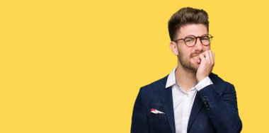 Stresli ve gergin elle çivi ısırma ağzına bakarak gözlüklü genç yakışıklı iş adamı. Anksiyete sorunu.