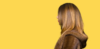 Güzel orta yaş vizon ceket arıyor giyen zarif kadın, yan, doğal yüz emin gülümseme ile pozuyla profil sakin ol için.