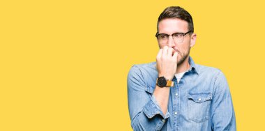 Gözlük giyen yakışıklı adam vurgulandı ve ağız ısırma çivi elleri ile gergin. Anksiyete sorunu.