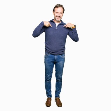 Yüzünde gülümseme ile kendinden emin görünüyorsun, kendini gururlu ve mutlu parmakları ile işaret kazak giyen orta yaş yakışıklı adam.