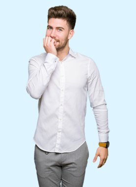 Genç yakışıklı iş adamı stresli ve gergin elle çivi ısırma ağzına bakıyor. Anksiyete sorunu.