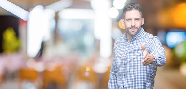 Joven Hombre Guapo Sobre Fondo Aislado Sonriendo Amistoso Ofreciendo Apretón —  Fotos de Stock