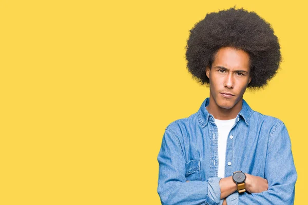 Young african american man with afro hair skeptic and nervous, disapproving expression on face with crossed arms. Negative person.