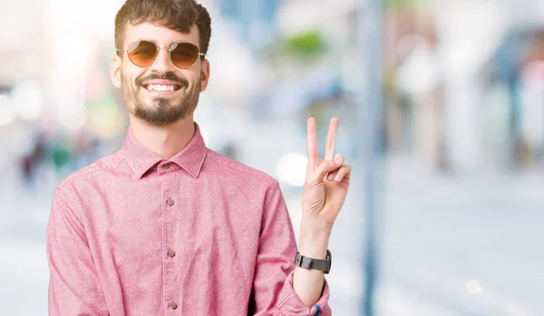 Homem Bonito Jovem Usando Óculos Sol Sobre Fundo Isolado Sorrindo — Fotografia de Stock